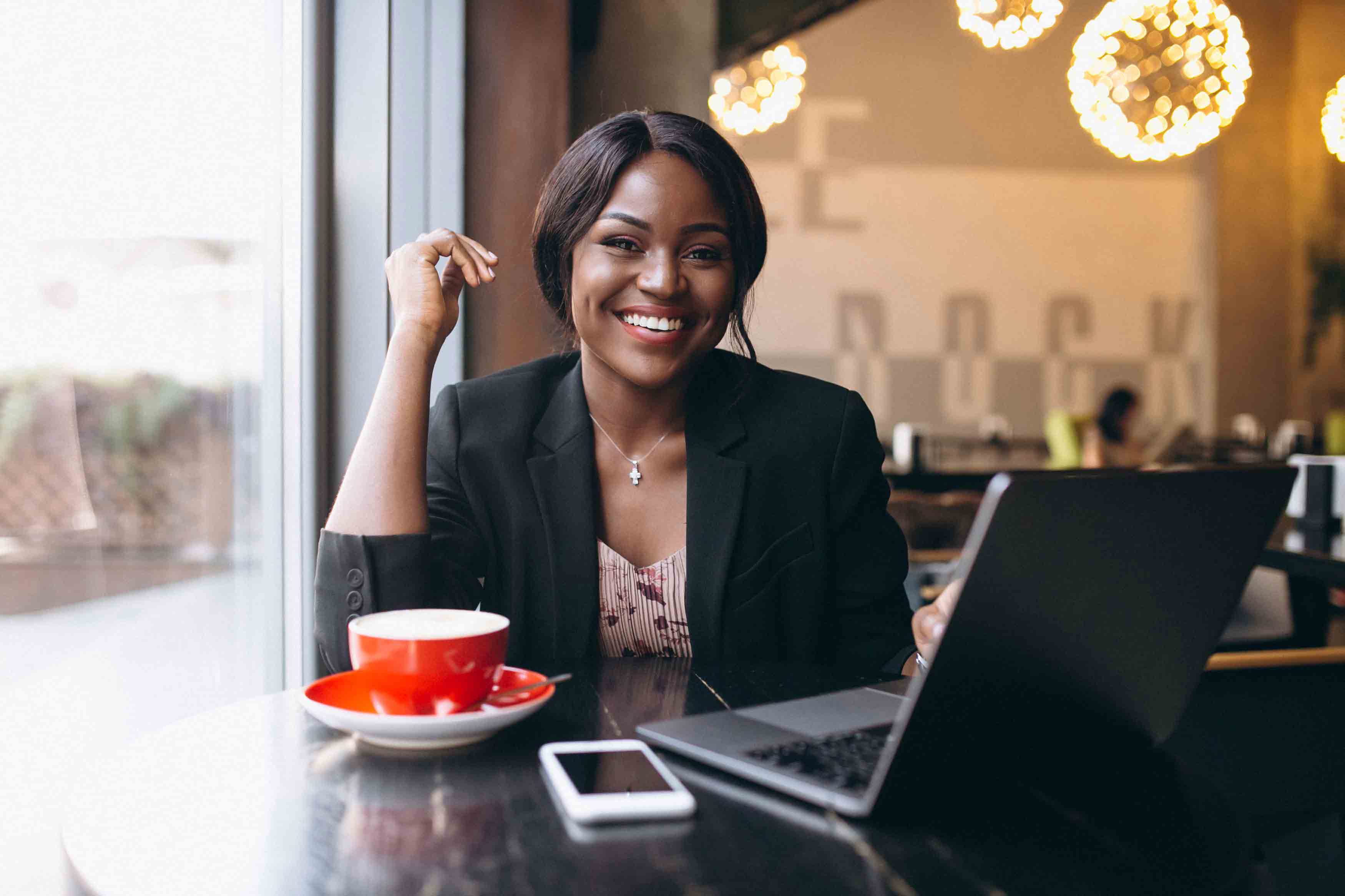 Happy entrepreneur working from cafe with laptop
